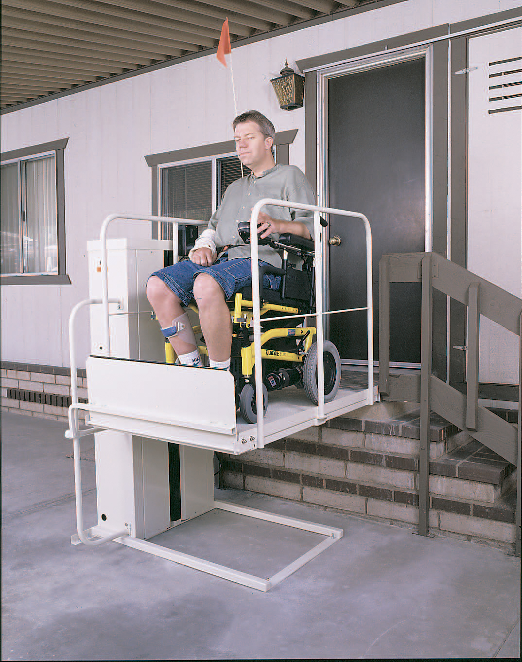 MACS PL50 porch lift with wheelchair user at a residential entrance